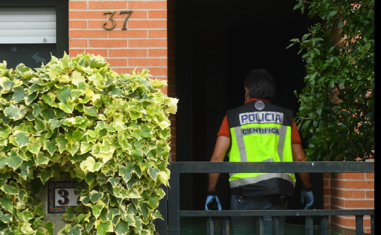 Un agente de policía accede al interior de la vivienda donde tuvo lugar el suceso. 