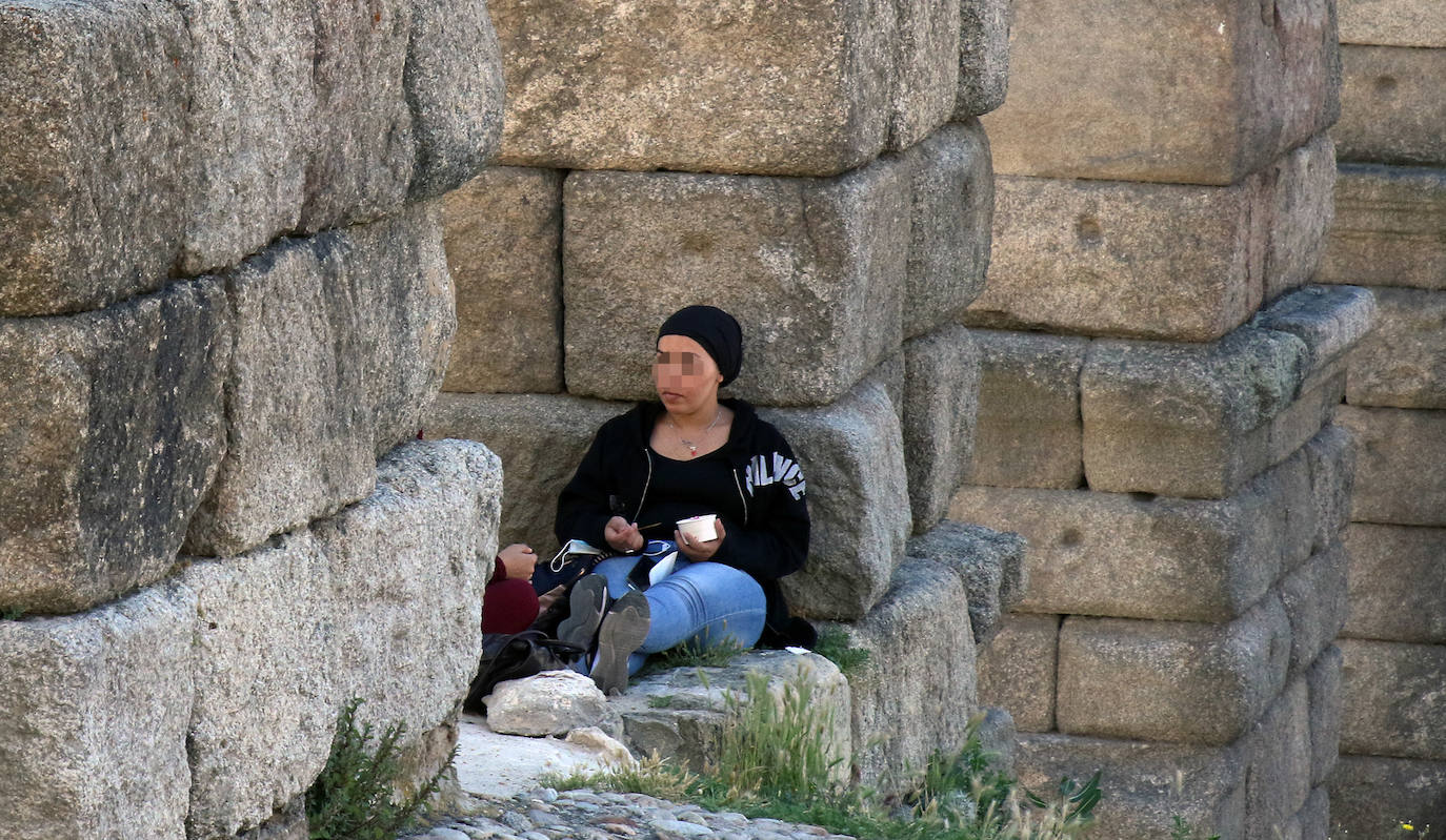 Una mujer, sentada sobre los sillares del Acueducto, conducta que será sancionada con la nueva ordenanza de convivencia ciudadana. 