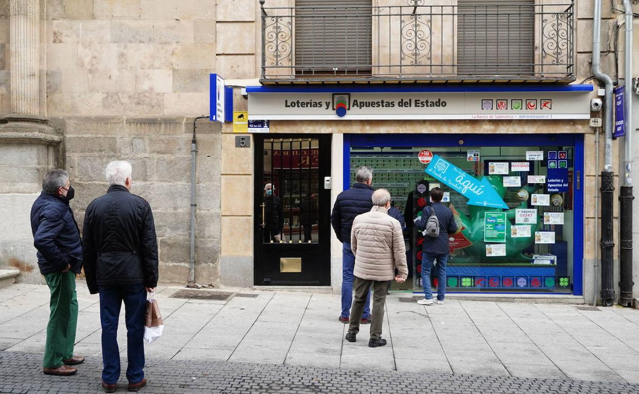 Clientes delante de una admnistración de lotería. 