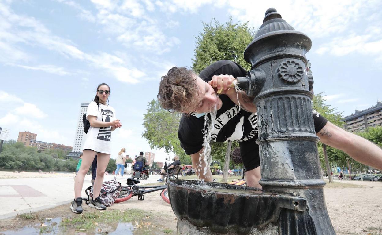 Un joven se refresca en la fuente de Las Moreras.