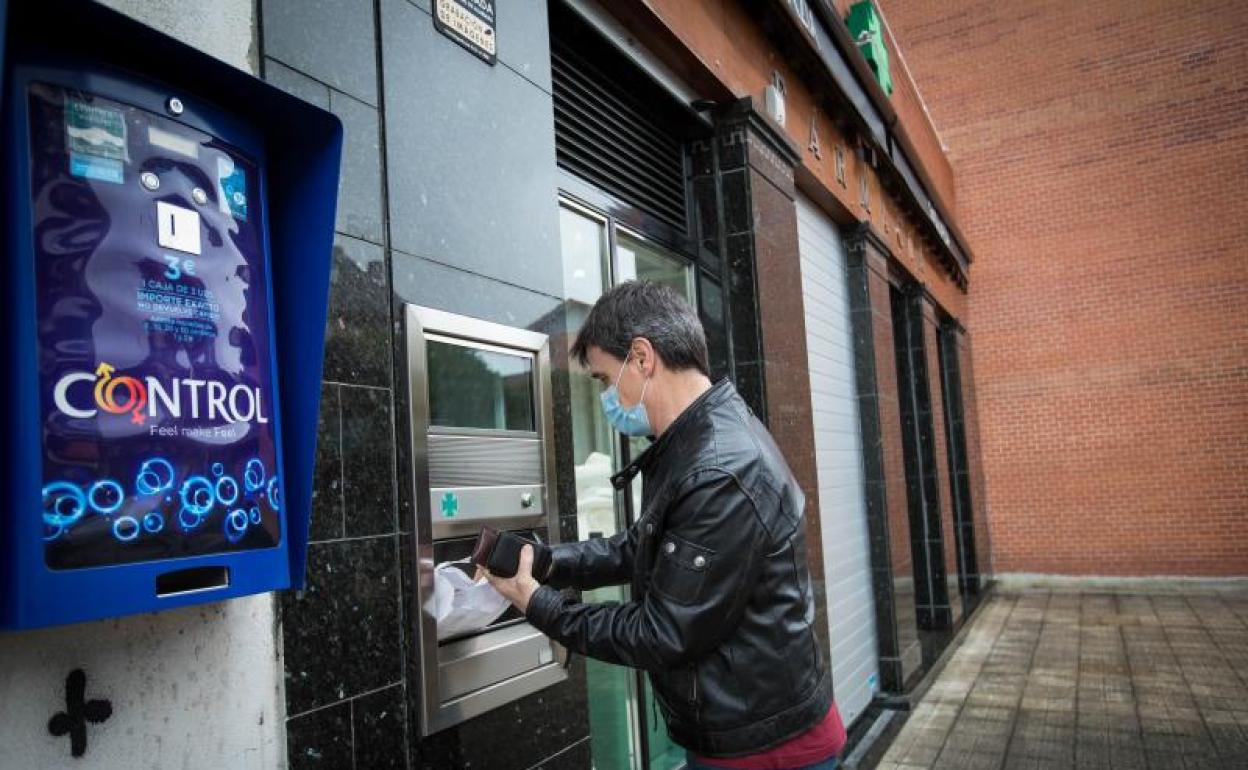 Un hombre realiza una compra en una farmacia de guardia.