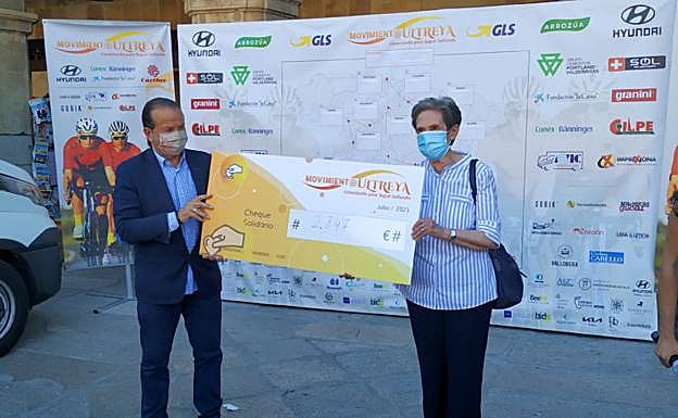 Carmen Calzada, directora de Cáritas Diocesana de Salamanca, recibe el cheque del dinero recaudado