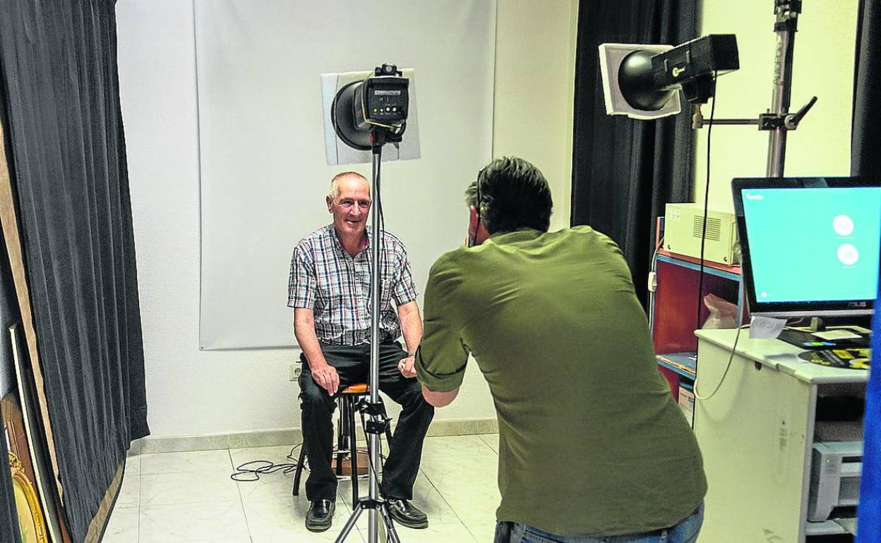 Fernando López toma una fotografía de DNI en su estudio.