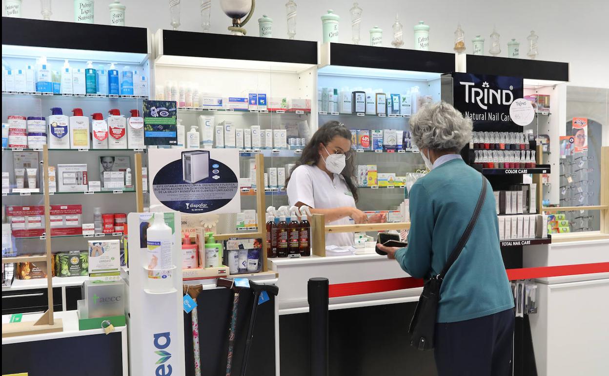 Una clienta compra en una farmacia de Palencia. 