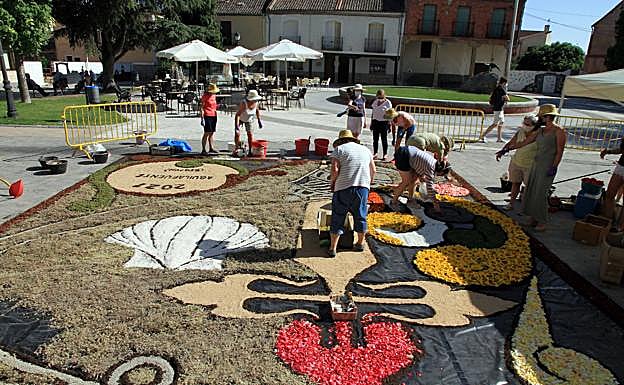 Los vecinos confeccionan la alfombra. 