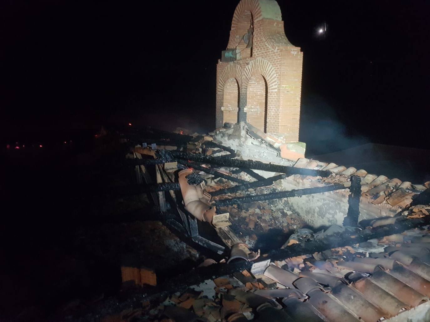 Vigas carbonizadas junto a la torre campanario, esta madrugada en Ampudia. 