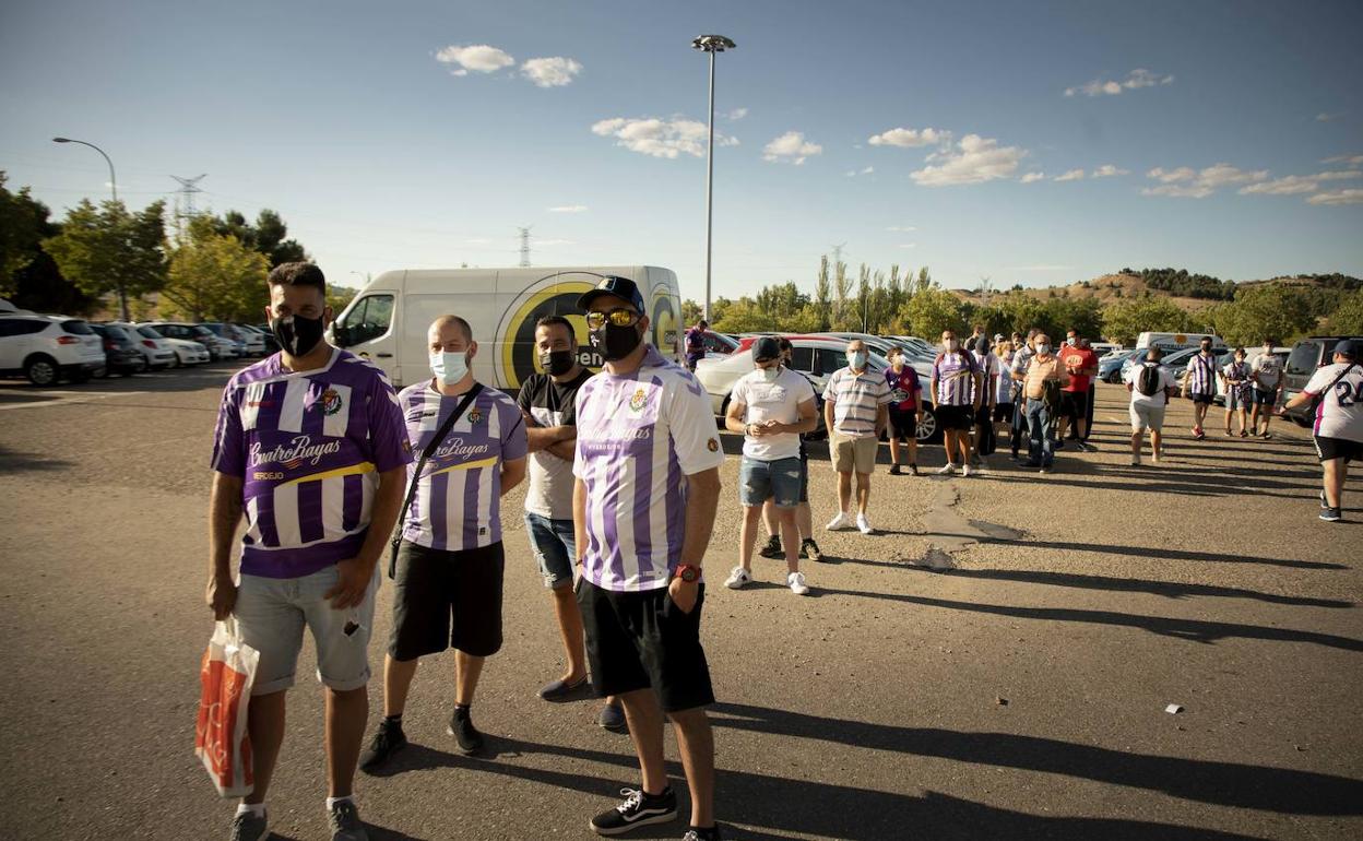 Un grupo de abonados hace cola antes de entrar al estadio para presenciar el partido del trofeo. 