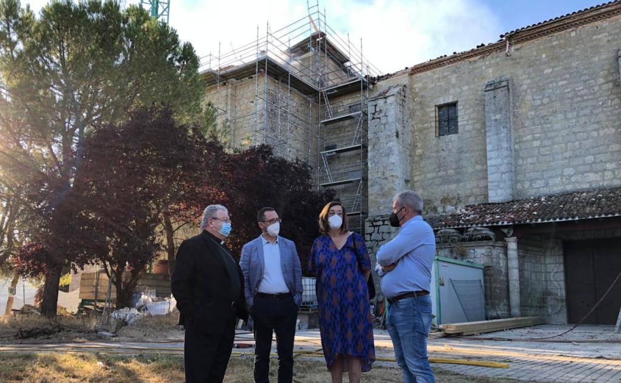 La presidenta de la Diputación y el director general de Patrimonio, con el obispo, junto al monasterio, en el que se aprecia el andamiaje de las obras. 