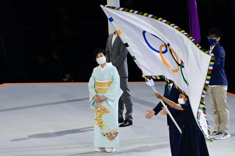 La alcaldesa de París, Anne Hidalgo, recibe la bandera olímpica mientras suena en el Estadio de Tokio el himno de Francia.