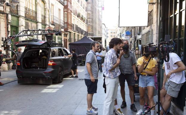 Imagen principal - Arriba, el director supervisa varios momentos del rodaje. Debajo, un momento del número musical y los figurantes, a la espera de entrar en acción. 