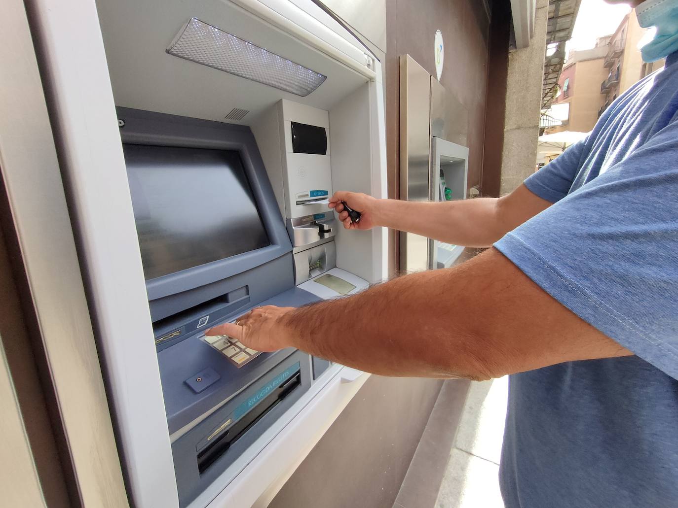 Un hombre introduce la tarjeta en un cajero de la ciudad para sacar dinero.