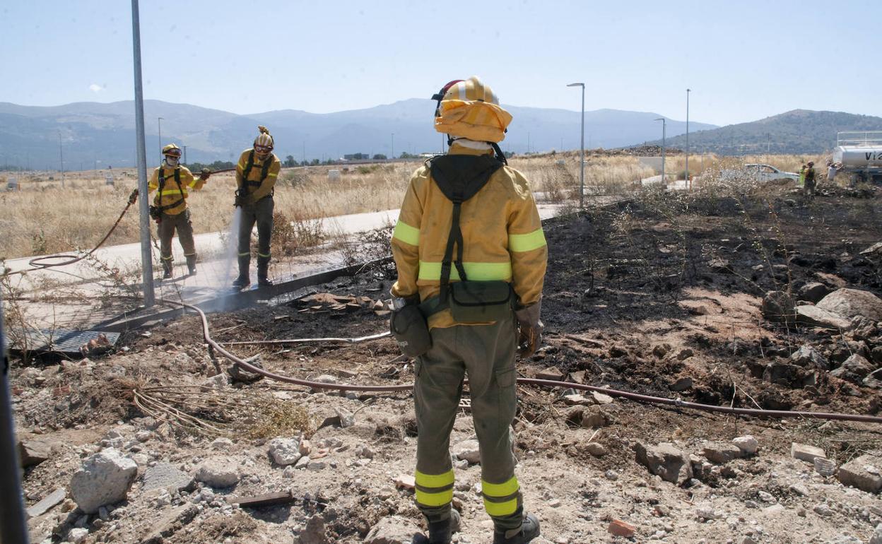 Espcialistas en la lucha contra el fuego refrescan el terreno después de extinguir el incendio de este viernes en la zona del Carrascalejo. 