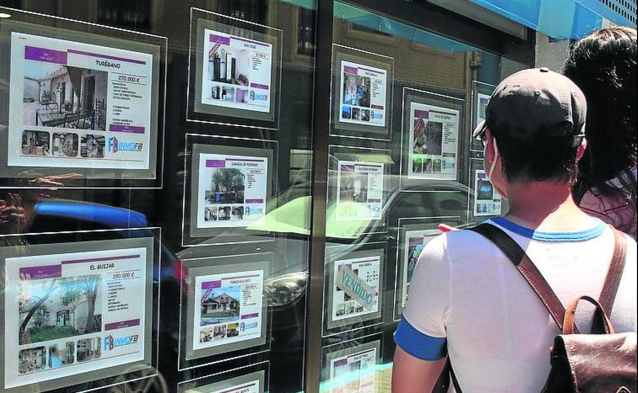 Escaparate con ofertas de pisos y casas en una inmobiliaria. 