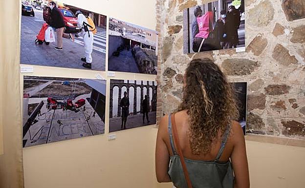 Una visitante contempla varias fotografías de la exposición.