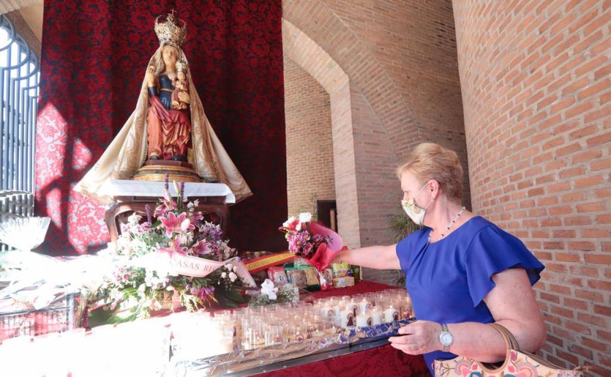 Momento en el que una vallisoletana deposita un ramo de flores en el altar de la virgen. 