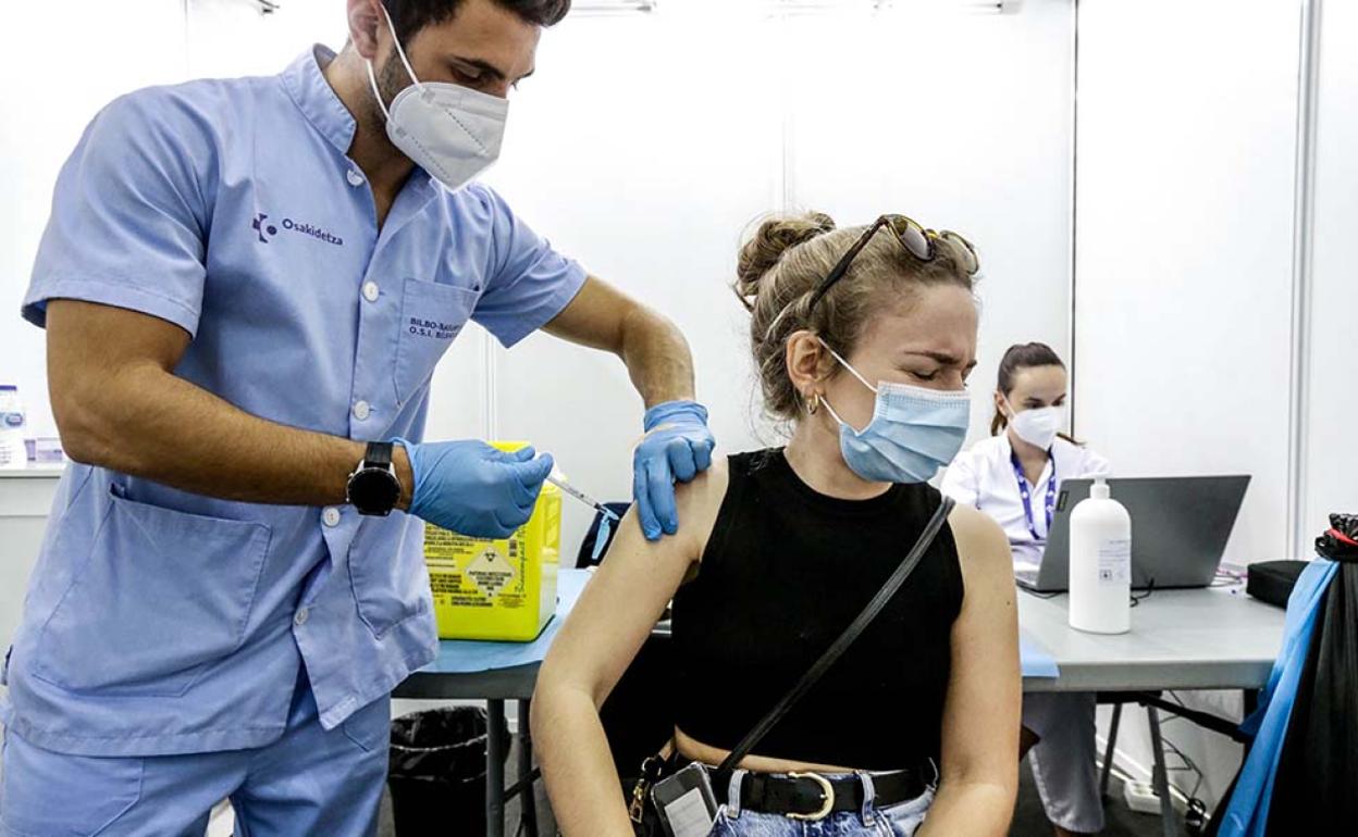 Un sanitario vacuna a una mujer. 