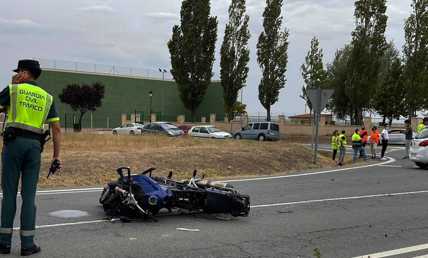 Un guardia civil, junto a la moto en la que viajaban los dos heridos.