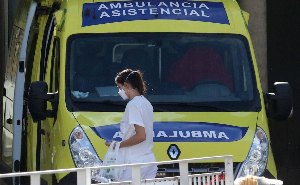 Una sanitaria pasa delante de una ambulancia aparcada junto al Hospital General de Segovia.