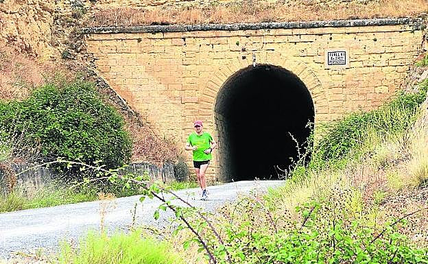 Un deportista sale de uno de los túneles del antiguo ferrocarril. 