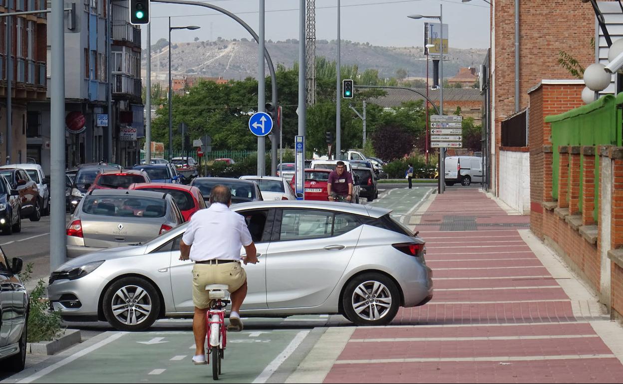 Dos ciclistas se cruzan con un coche a la salida de la Comisaría de la Policía Nacional de Delicias por la calle Padre Benito Menni. 