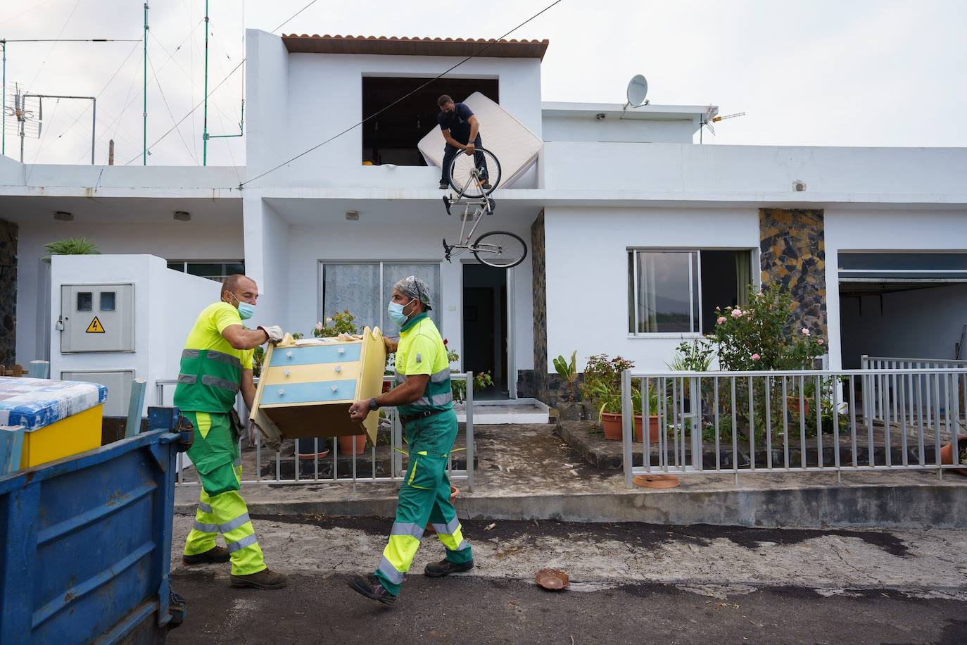 Un hombre del núcleo urbano de Todoque saca su bicicleta por la ventana