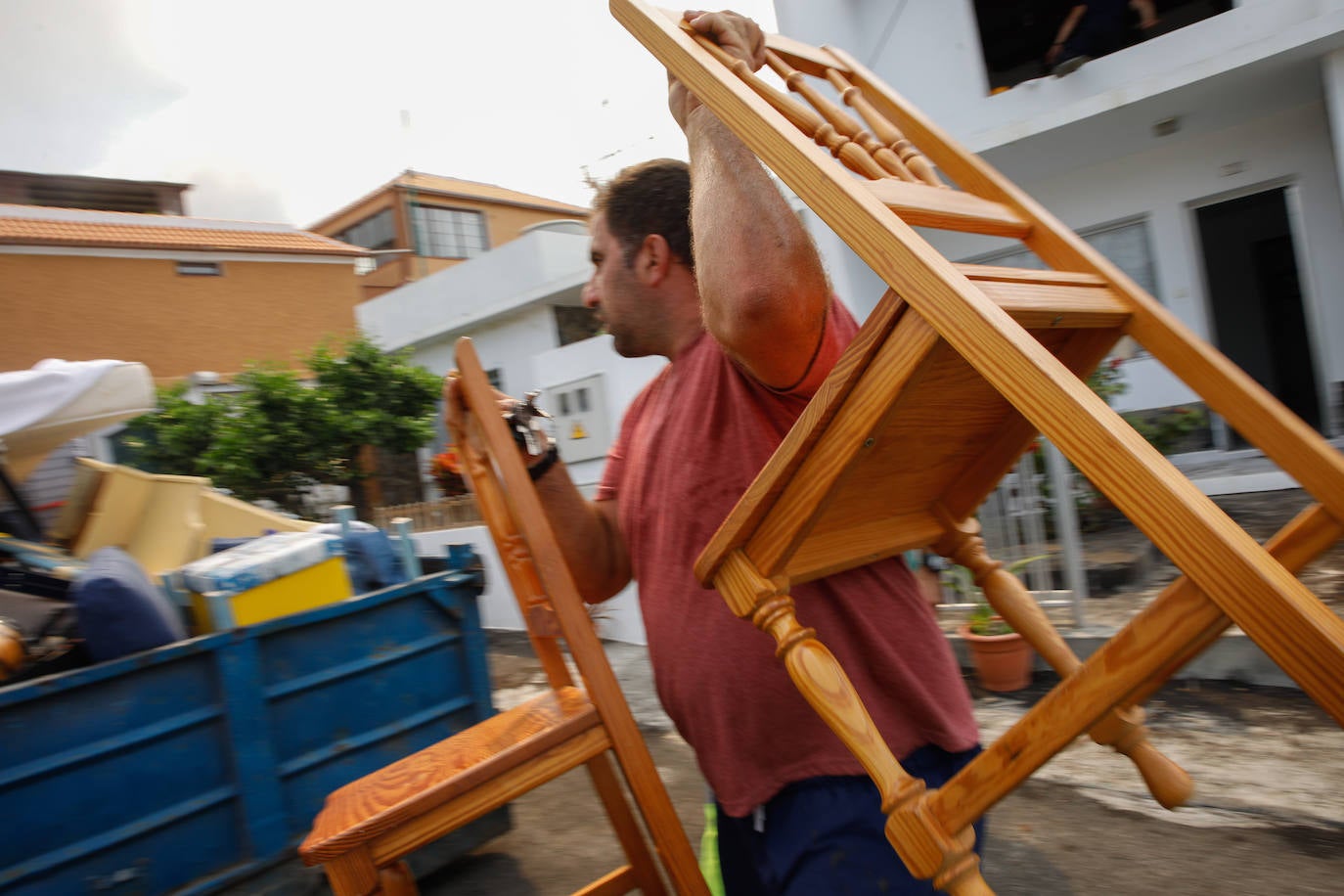 Un hombre del núcleo urbano de Todoque recoge sus sillas durante el desalojo de su vivienda