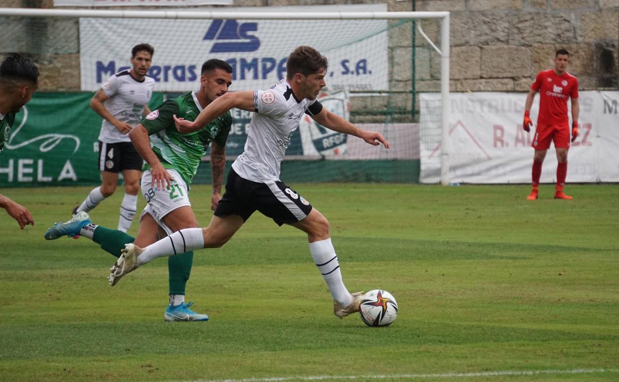 Amaro conduce el balón ante un rival del Arenteiro. 