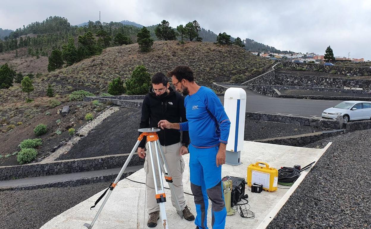Carlos Toledano (izquierda), y un compañero de AEMET, preparan el medidor de partículas en La Palma. 