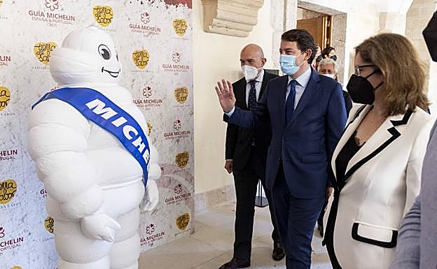 Alfonso Fernández Mañueco saluda al Bibendum, el muñeco Michelin, a su llegada a Abadía Retuerta, junto al consejero Jesús Julio Carnero. 