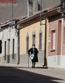 Imagen secundaria 2 - El bar es un punto de encuentro social en Villaverde. Abajo, Miguel Ángel Cocero y Emilio Pariente. En la imagen vertical, Julia Ordóñez pasea por una calle.