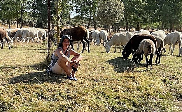 Almudena en el campo mientras pastan sus ovejas.