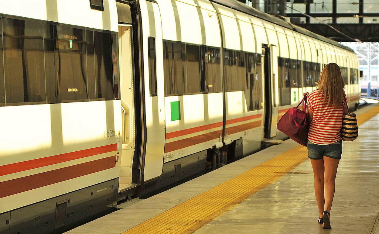 Una joven camina por el andén de una estación de tren.
