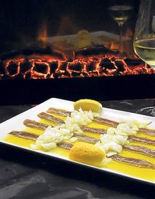 Imagen secundaria 2 - Arriba, El Establo cuenta con terraza en la calle Alarcón; debajo, a la izquierda, dos de los famosos 'romeritos', en este caso de pulpo y de salmón; a la derecha, bandeja de sardinas en aceite aliñadas con sal y limón.