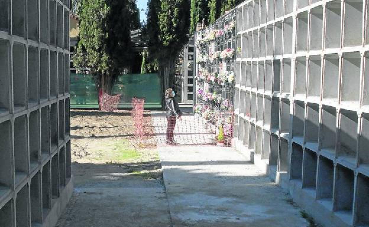 Una mujer reza a un ser querido junto a las nuevas paredes de nichos construidas este año en el cementerio municipal de Segovia. 