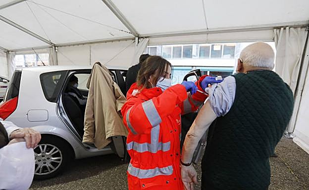 Una enfermera pone la vacuna a un nonagenario que acudió en coche, esta mañana en el aparcamiento de La Puebla. 