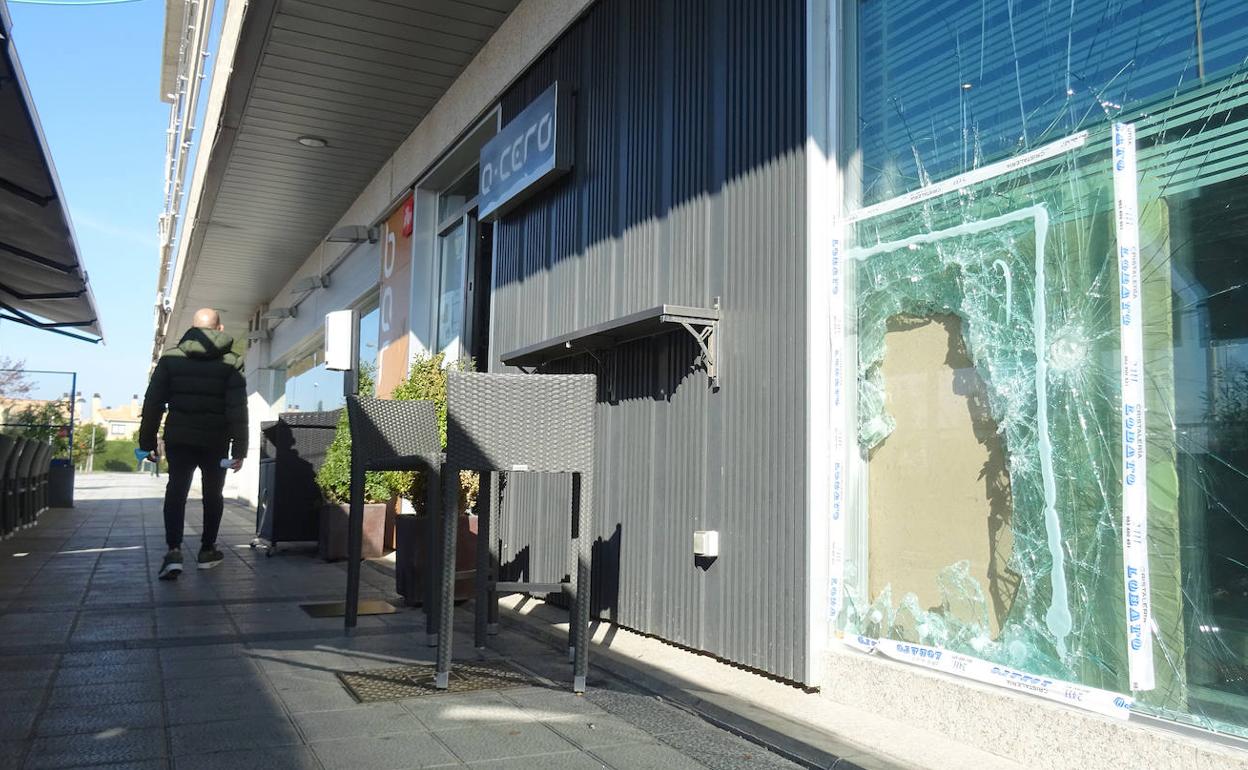 Cristal de seguridad roto a mazazos por los delincuentes en el bar Acero de la calle Alcaparra. 