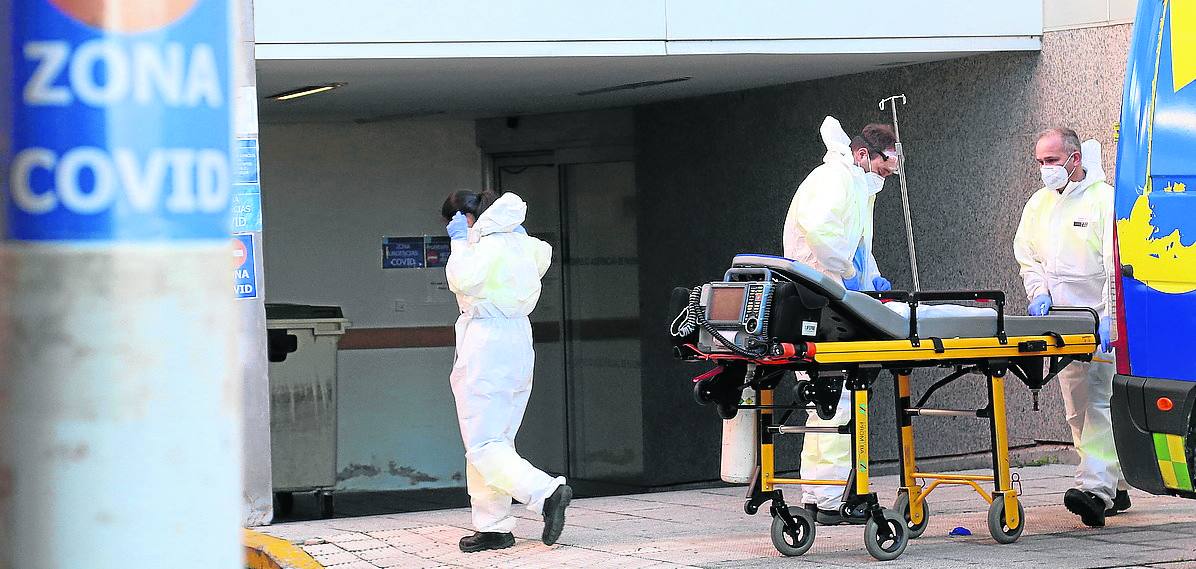 Técnicos de emergencias, con una ambulancia en la zona covid del hospital en plena pandemia. 