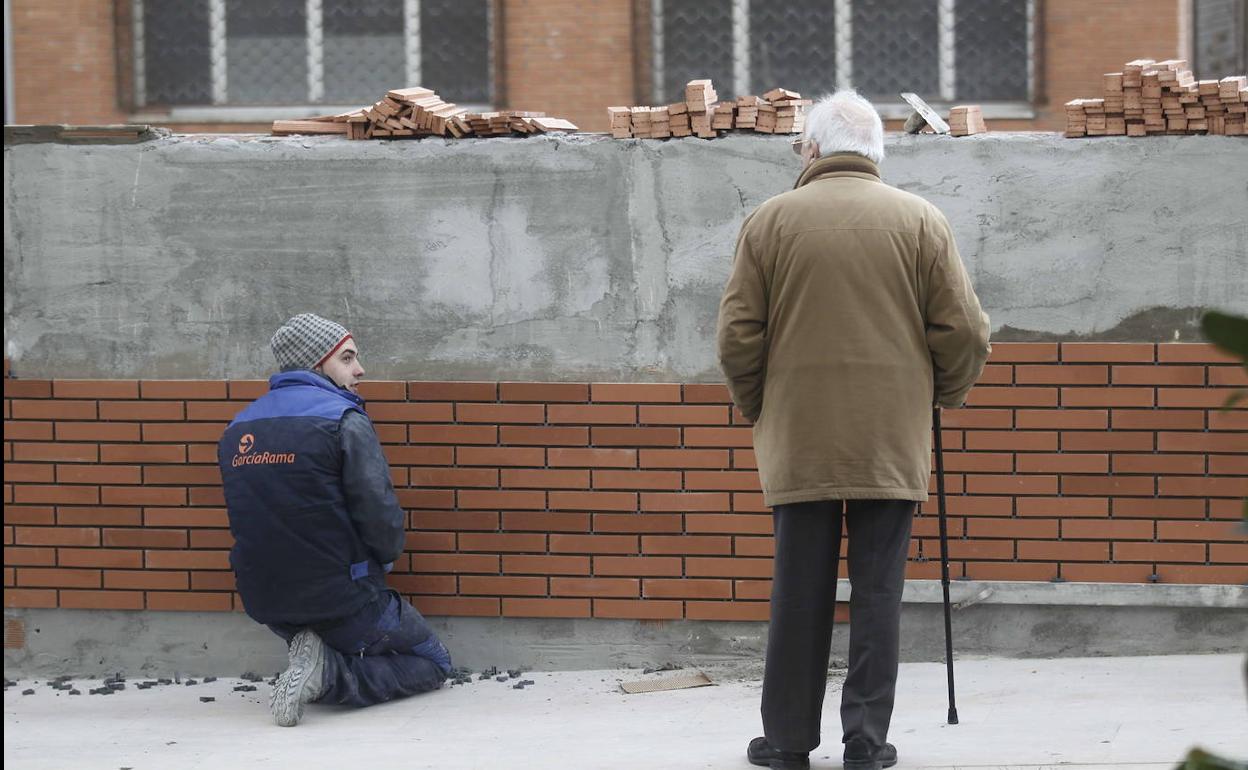 Un jubilado observa a un albañil hacer su trabajo en una imagen de archivo. 