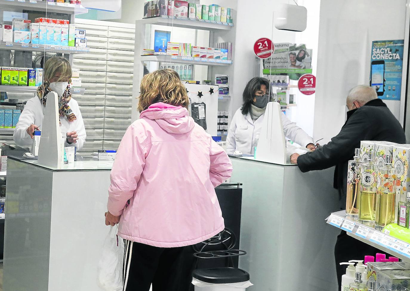 Dos personas adquieren medicamentos en una farmacia de la capital palentina. 