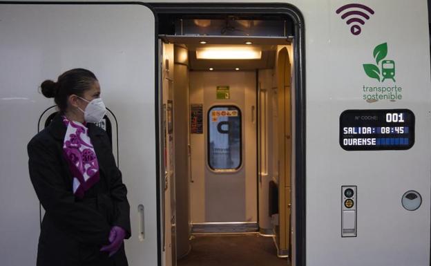 Una azafata en las puertas del tren que va a efectuar un viaje por el nuevo tramo de alta velocidad Pedralba de la Pradería-Ourense, en la estación de Madrid-Chamartín. 