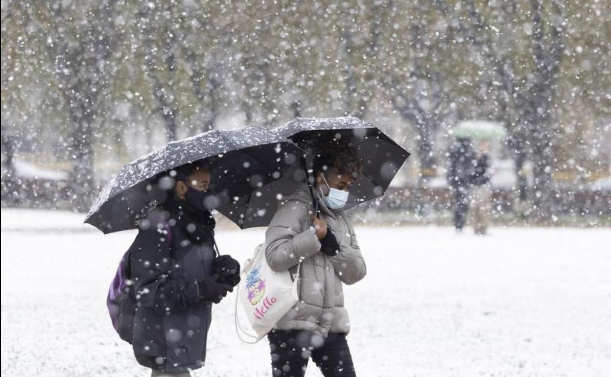 Dos jóvenes se protegen de la nevada caída el miércoles. 