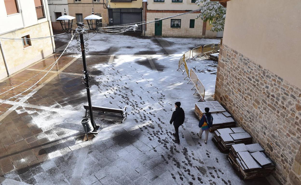 Dos niños caminan por una calle nevada de Aguilar, a mediodía del sábado.