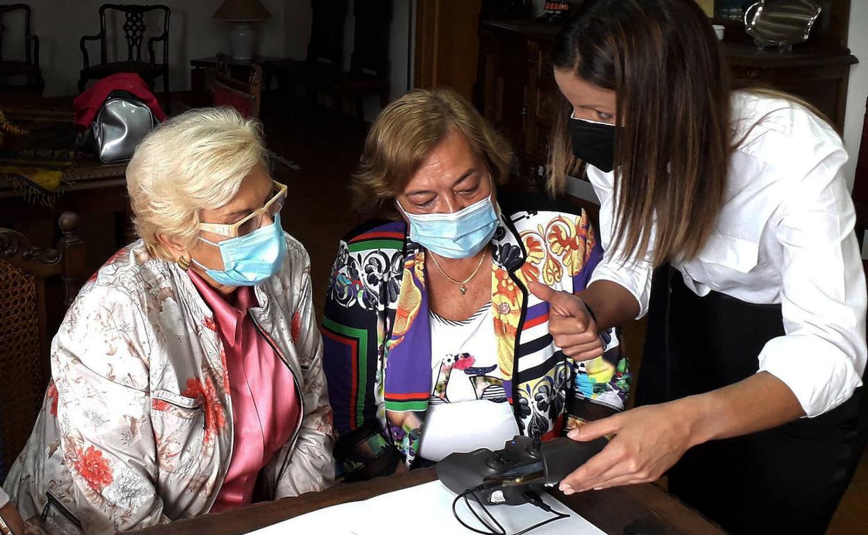 Juana Borrego, presidenta de Femur, junto a Elena García Gil, secretaria de la asociación, aprenden a manejar un dron. 