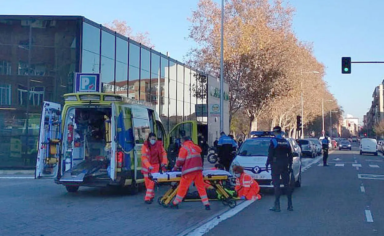 Sanitarios y agentes atienden al motorista herido en la colisión de la calle Arca Real. 