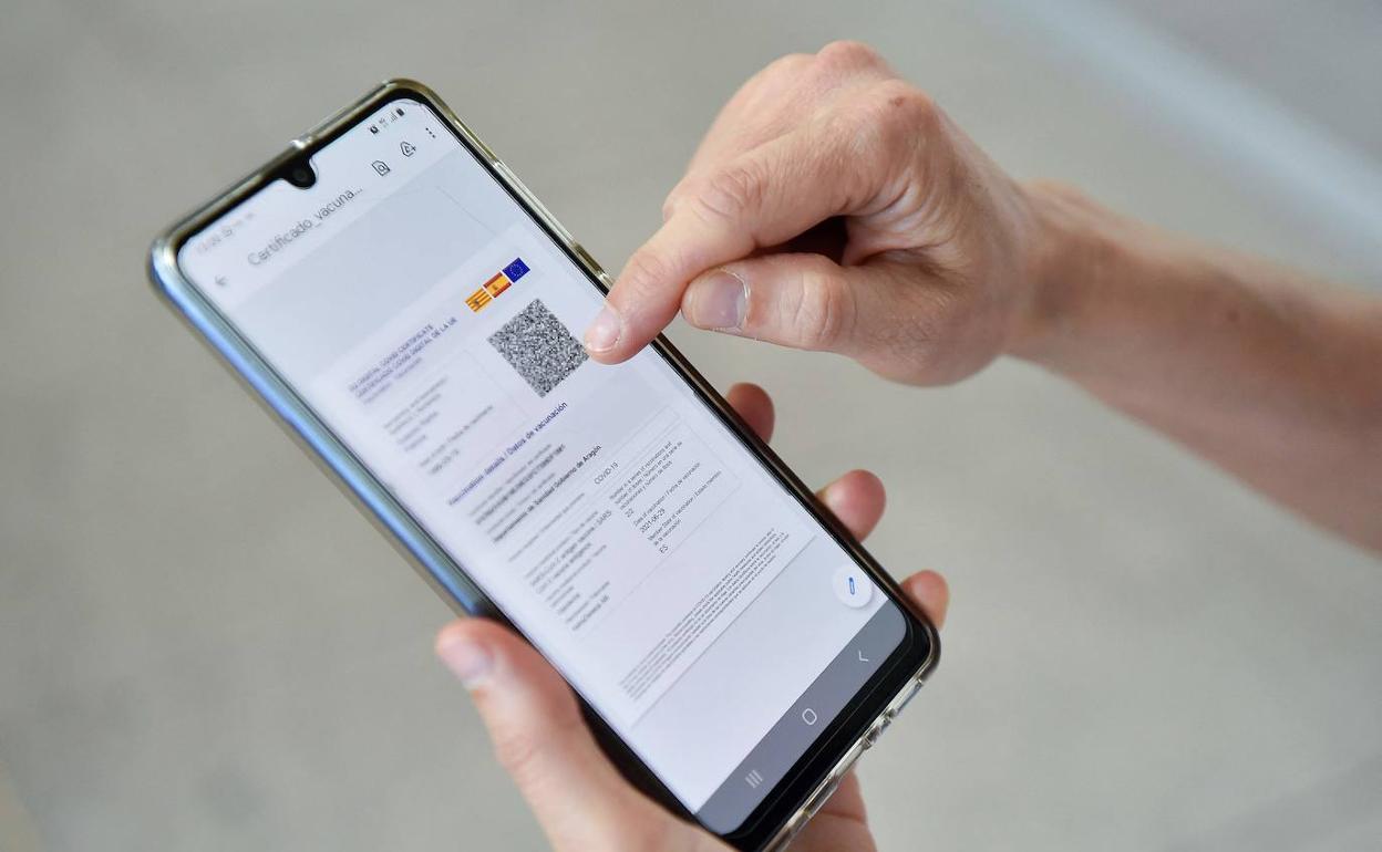 Una persona muestra su certificado covid.