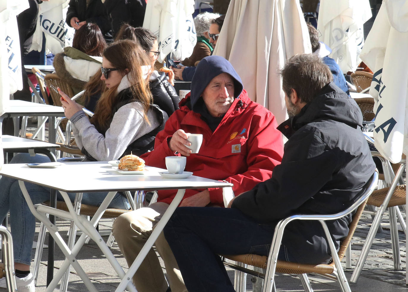 Dos hombres toman café en una terraza del centro de Segovia.