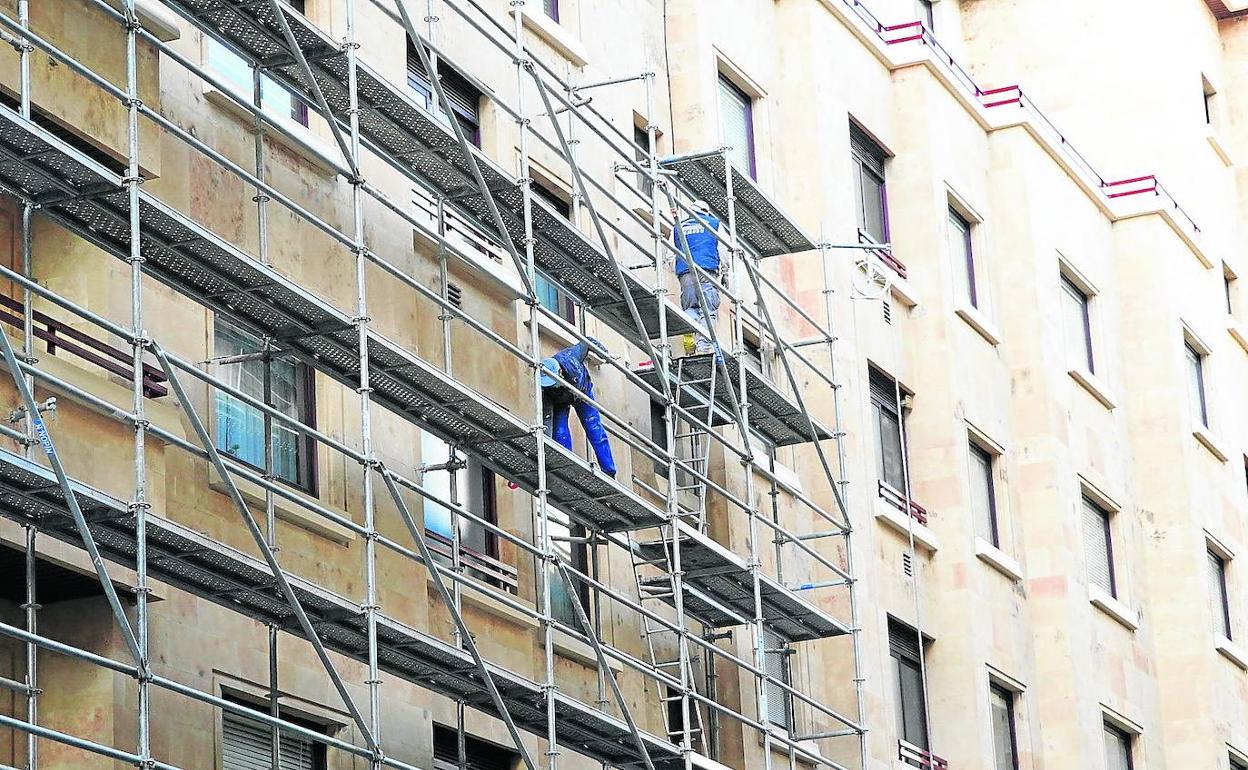 Trabajadores en un andamio en unso trabajaos de reforma de un afachada de un edificio.