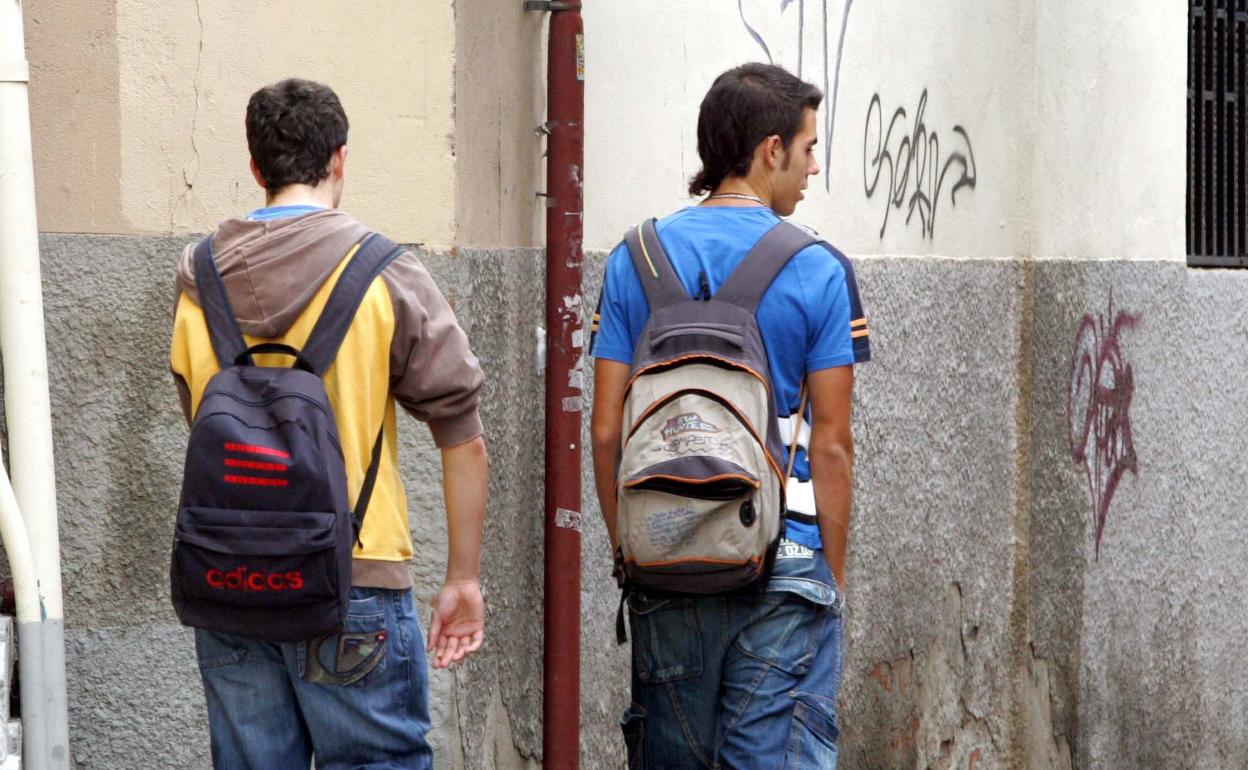 Dos alumnos de Secundaria con su mochilas al salir de clase.