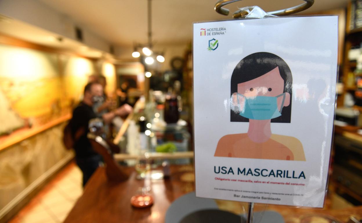 Cartel informativo del uso de mascarilla en un bar de Valladolid.