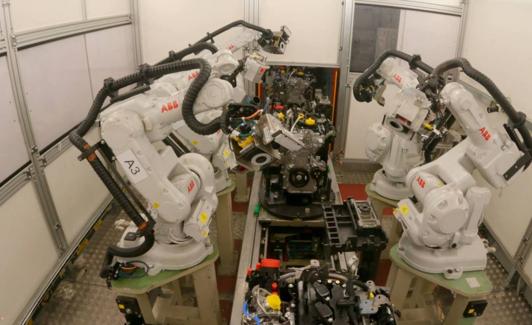Varias máquinas ensamblan un motor.